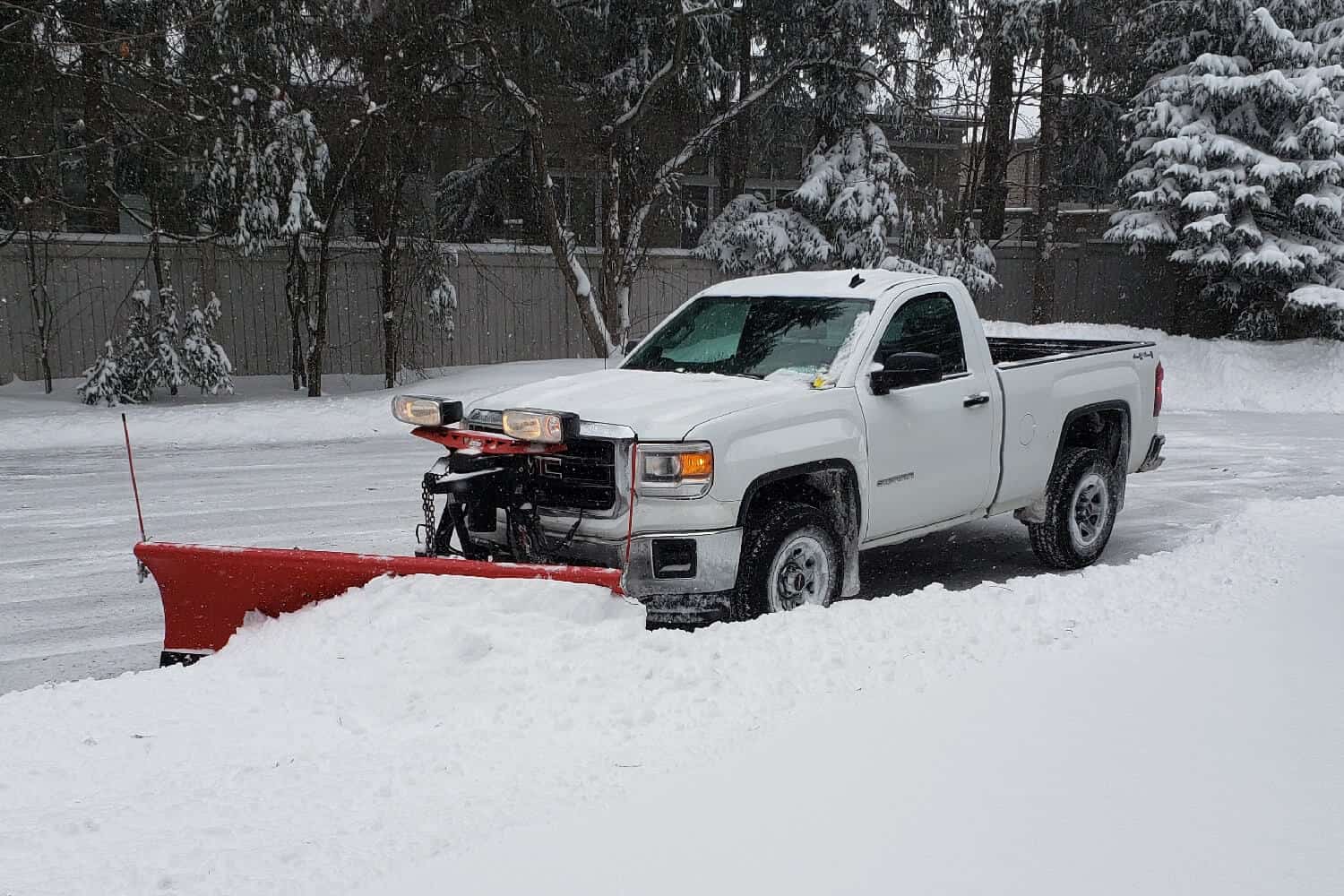 Skibo Services white truck equipped with a snow plow, ready to tackle winter's challenges with efficient snow removal services.